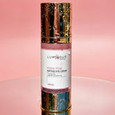 Luminous Empire Pink Peptide Eye Cream bottle on a pink background
