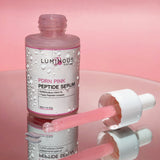 Luminous Pink Peptide Serum bottle with dropper on a pink background