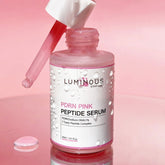 Luminous Peptide Serum bottle with dropper on a pink background
