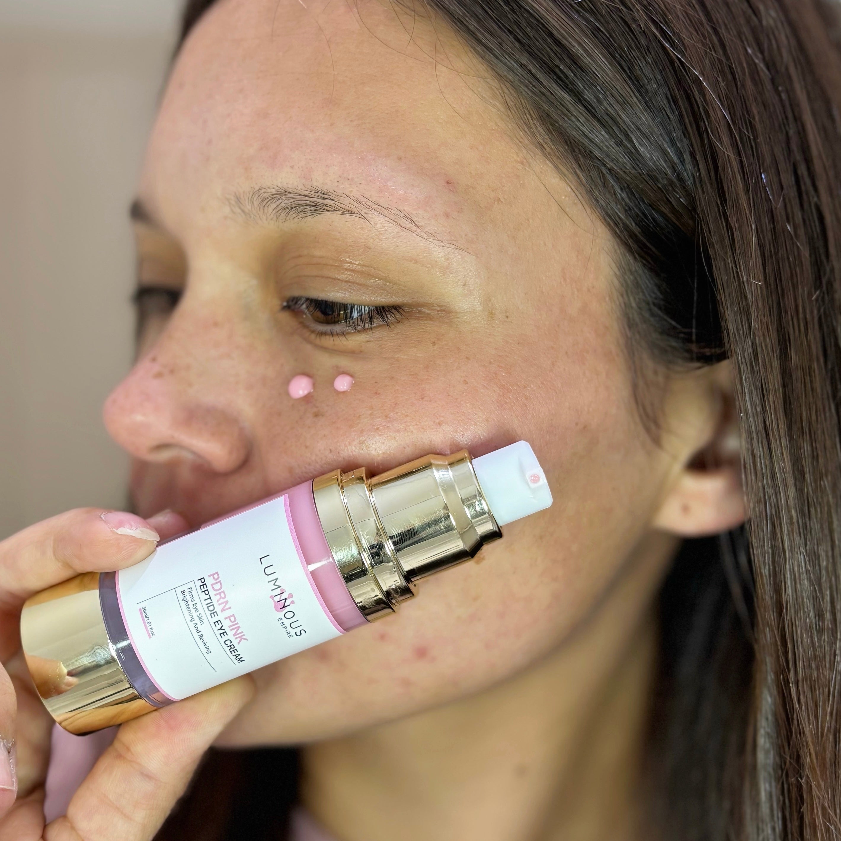Katie applying Luminous Empire Pink Peptide Eye Cream