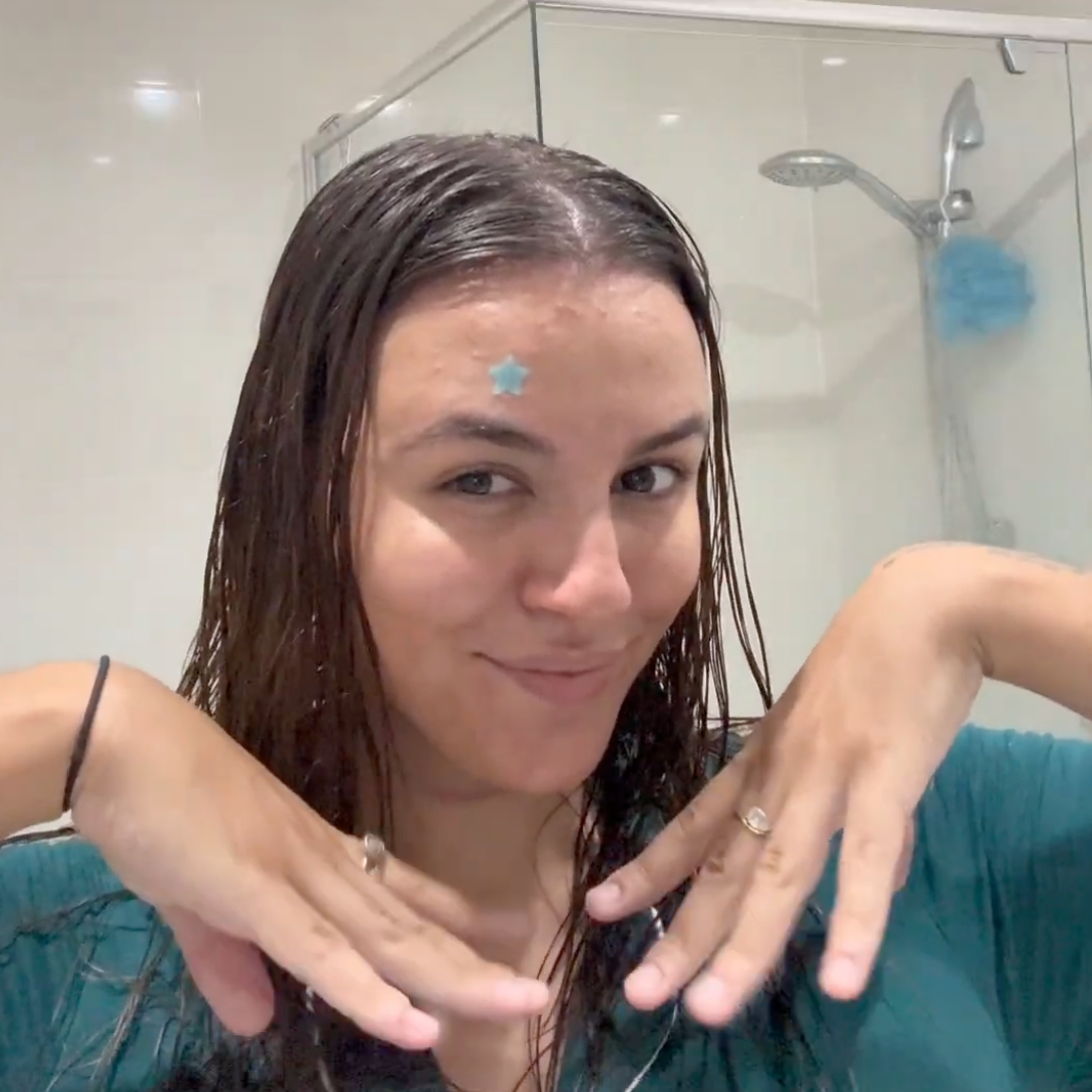 Happy Woman with wet hair in a bathroom setting using Pimple Patches